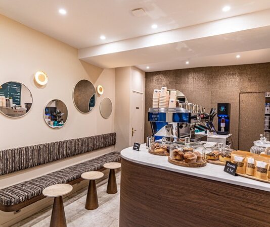 Kahve dükkanları, modern şehir yaşamının en güçlü sosyal alanlarından biri olarak öne çıkıyor. Günün erken saatlerinden geç vakitlere kadar açık olan bu mekânlar, yalnızca kahve tüketilen yerler olmanın çok ötesine geçmiş durumda. Kahve dükkanları, bireylerin çalıştığı, sosyalleştiği, dinlendiği ve hatta kendine zaman ayırdığı alanlar hâline gelerek şehir kültürünün merkezinde konumlanıyor. Konulu bir haber görseli.