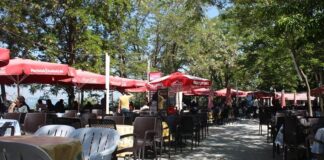 Çay bahçeleri, Türkiye’de gündelik yaşamın en köklü ve en yaygın sosyalleşme alanlarından biri olarak öne çıkıyor. Park kenarlarında, sahil şeritlerinde, mahalle aralarında ya da tarihi meydanlarda karşımıza çıkan çay bahçeleri, her yaştan insanın bir araya geldiği ortak buluşma noktaları olarak dikkat çekiyor. Bu mekânlar, sadece çay içilen yerler değil; sohbetin, dinlenmenin ve gündelik hayatın paylaşıldığı açık hava alanları olarak şehir kültürünün ayrılmaz bir parçası hâline gelmiş durumda. Konulu bir haber görseli.