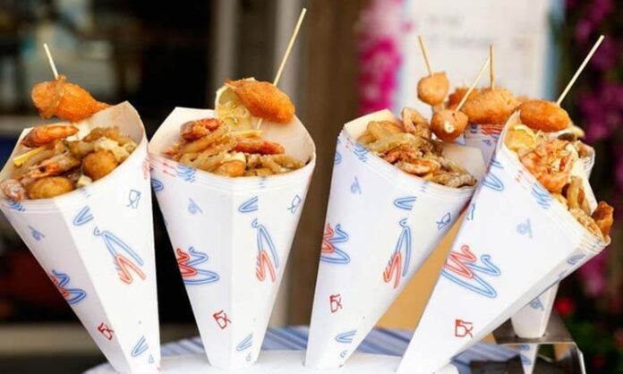 Sokak yemekleri standları, şehir yaşamının en canlı ve en erişilebilir gastronomi alanlarından biri olarak kabul ediliyor. Günün her saatinde farklı kesimlerden insanları bir araya getiren bu alanlar, yalnızca hızlı ve uygun fiyatlı yiyecekler sunmakla kalmıyor, aynı zamanda kentin kültürel dokusunu da yansıtıyor. Sokak yemekleri, geçmişten bugüne hem ekonomik hem de sosyal yönleriyle önemli bir yer tutarken, günümüzde gastronomi turizminin de vazgeçilmez parçalarından biri hâline gelmiş durumda. Konulu bir haber görseli.