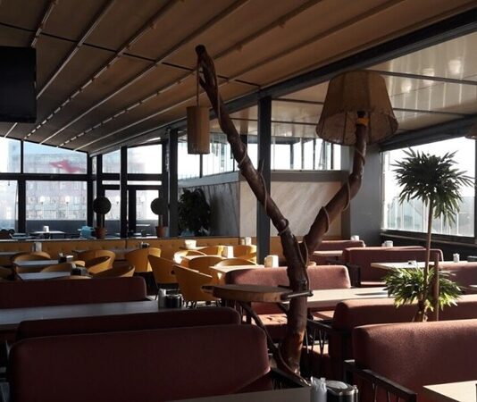 Şehir hayatının hızla akıp gittiği günümüzde insanlar, kalabalıktan uzaklaşabilecekleri ama şehirle bağlarını da koparmayacakları mekânlara yöneliyor. Bu noktada teras kafeler, hem manzara hem de atmosfer açısından sundukları avantajlarla dikkat çekiyor. Yüksek bir noktadan şehri izlerken kahve içmek ya da gün batımını izlemek, modern şehir kültürünün önemli bir parçası hâline gelmiş durumda. Özellikle büyük şehirlerde, beton yoğunluğunun artmasıyla birlikte teraslara olan ilgi her geçen gün daha da artıyor. Konulu bir haber görseli.